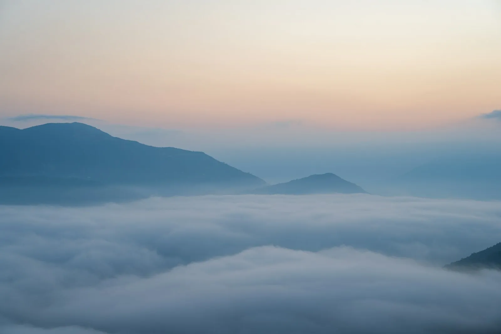 Mountain peaks emerging from a sea of clouds at dawn