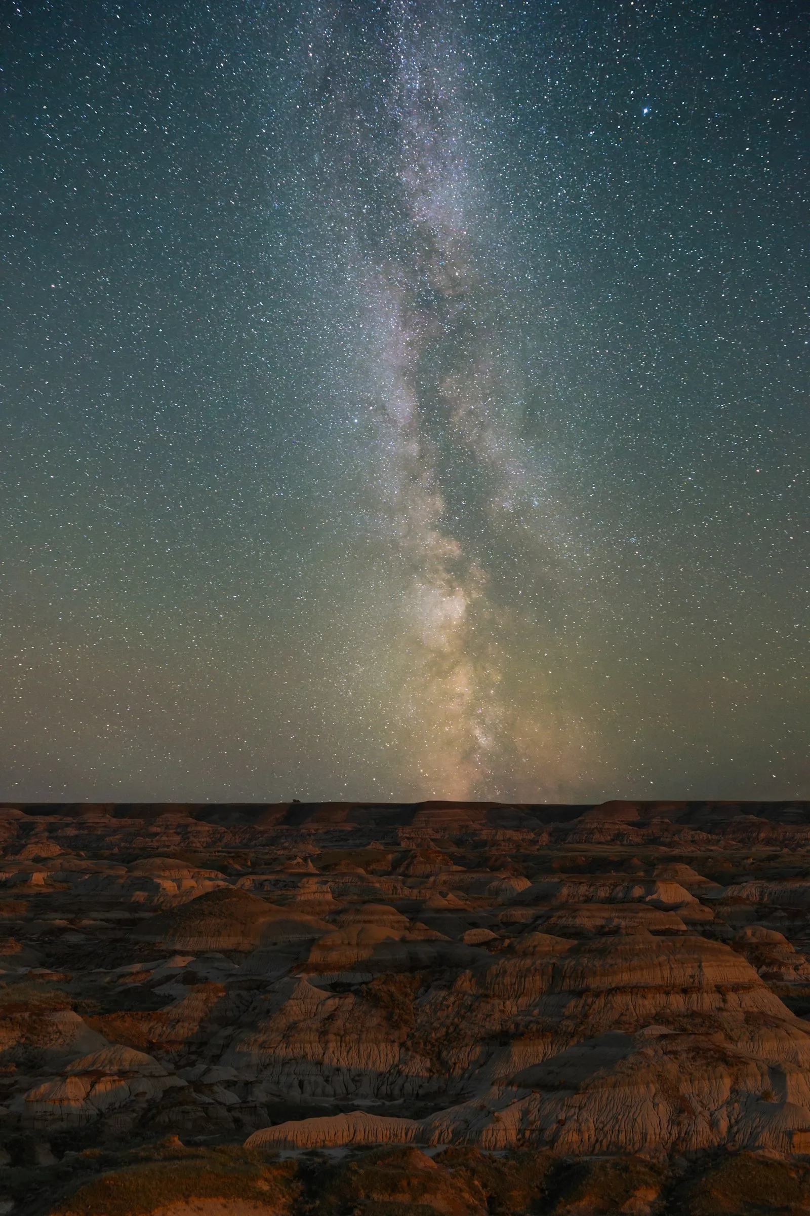 The Milky Way above a rugged desert landscape