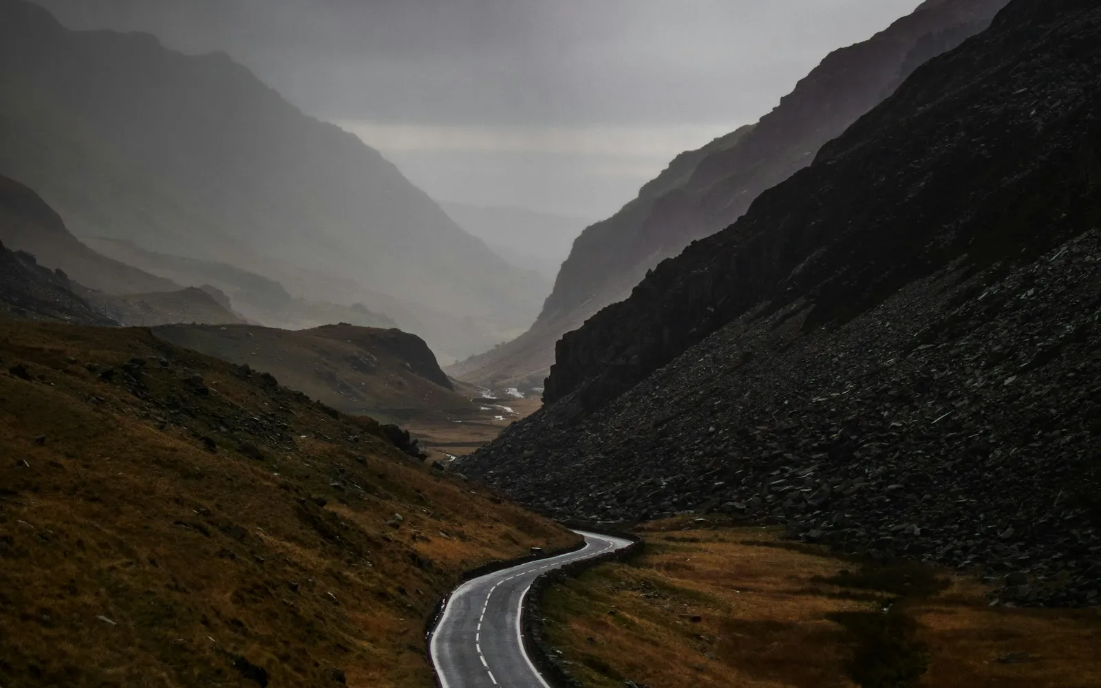 A narrow road winding between gray mountain slopes