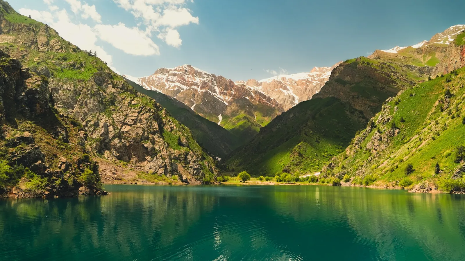 A calm mountain lake beneath a colorful sky