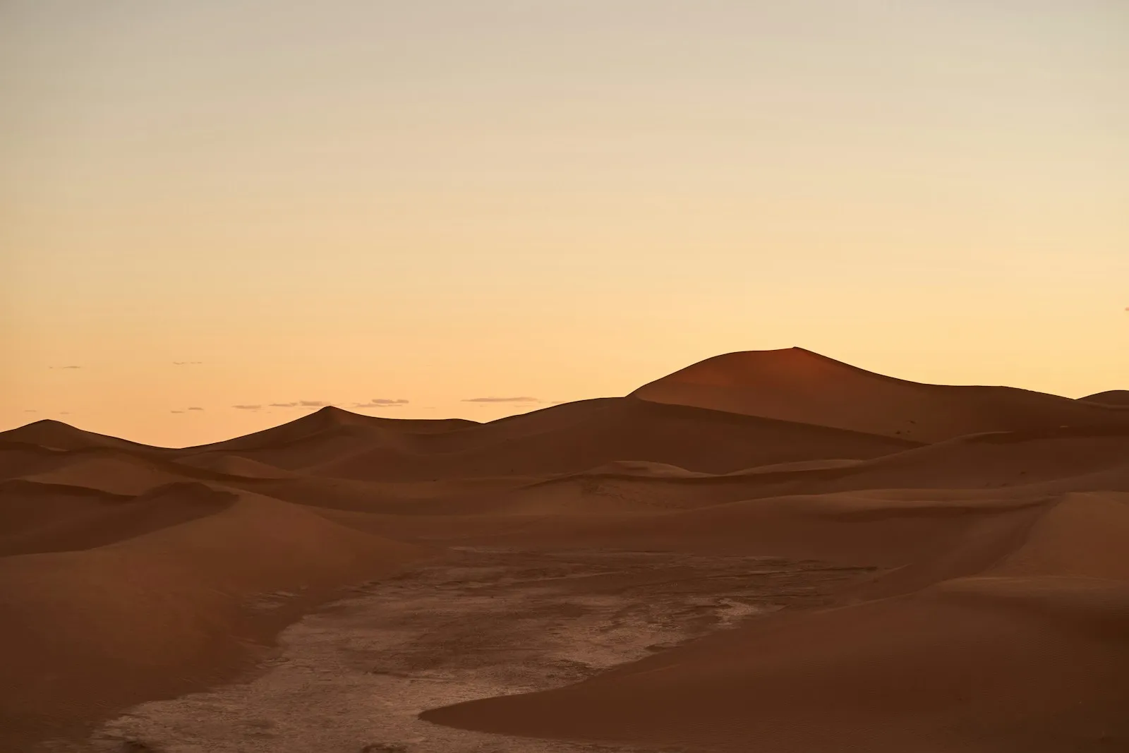 Red sand and rock formations beneath a hazy sky
