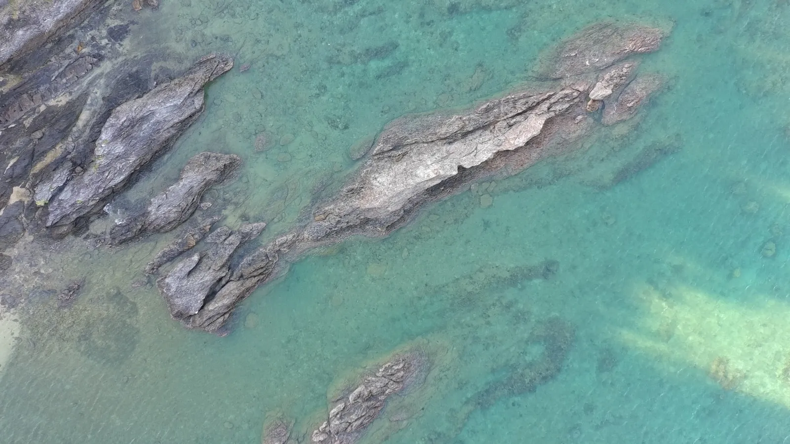 Turquoise water surrounding a rugged coastline