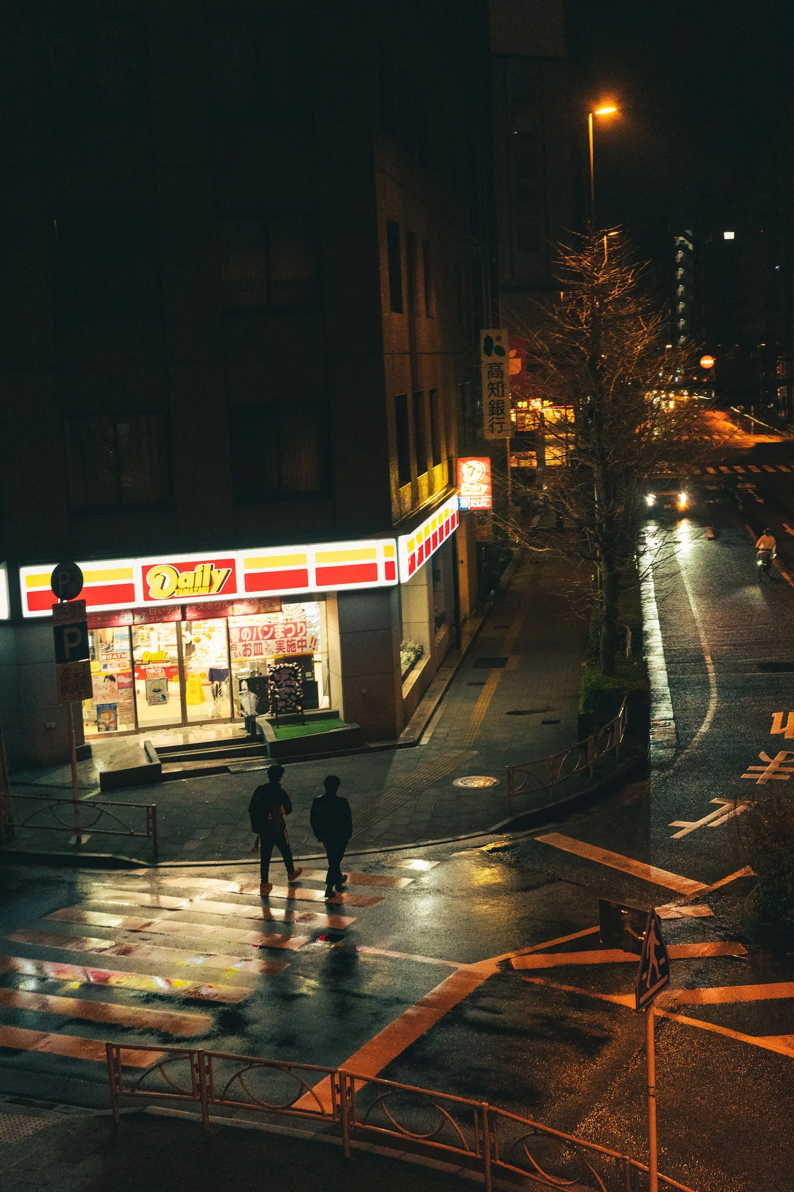 A convenience store glowing on a rainy night