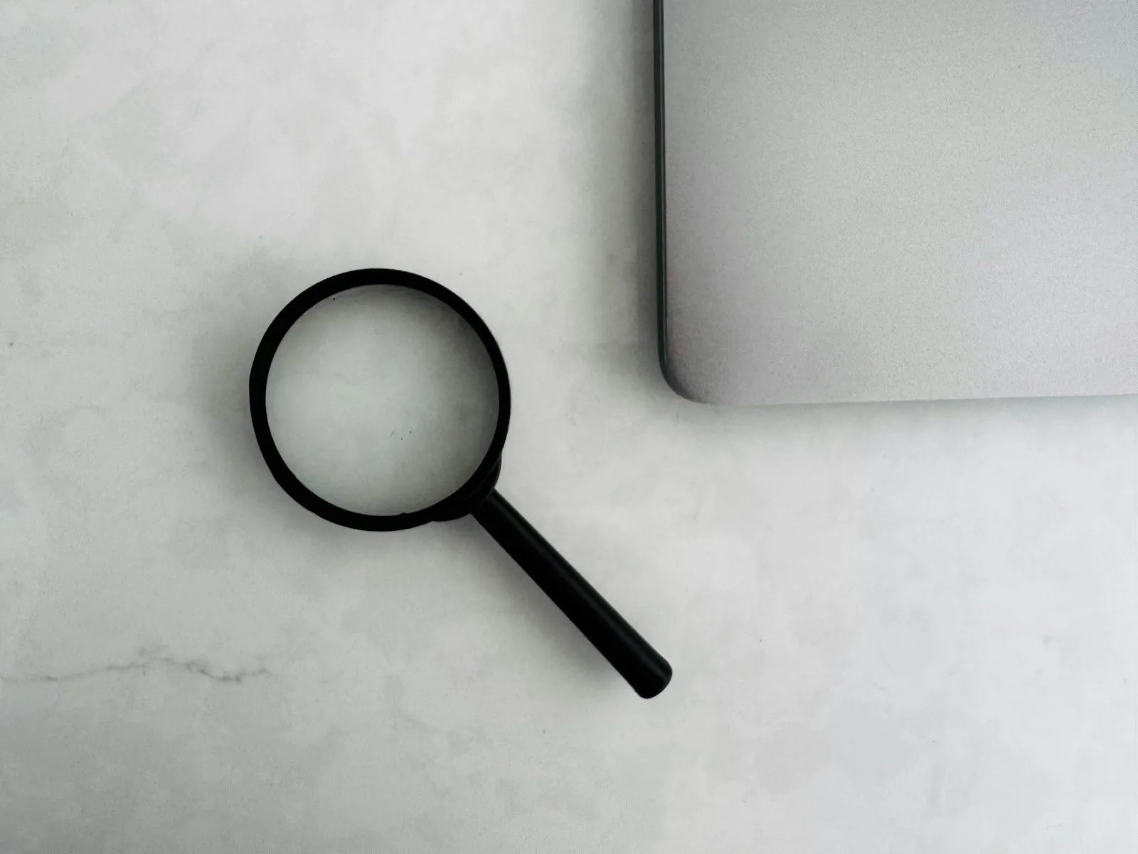 A magnifying glass beside a laptop
